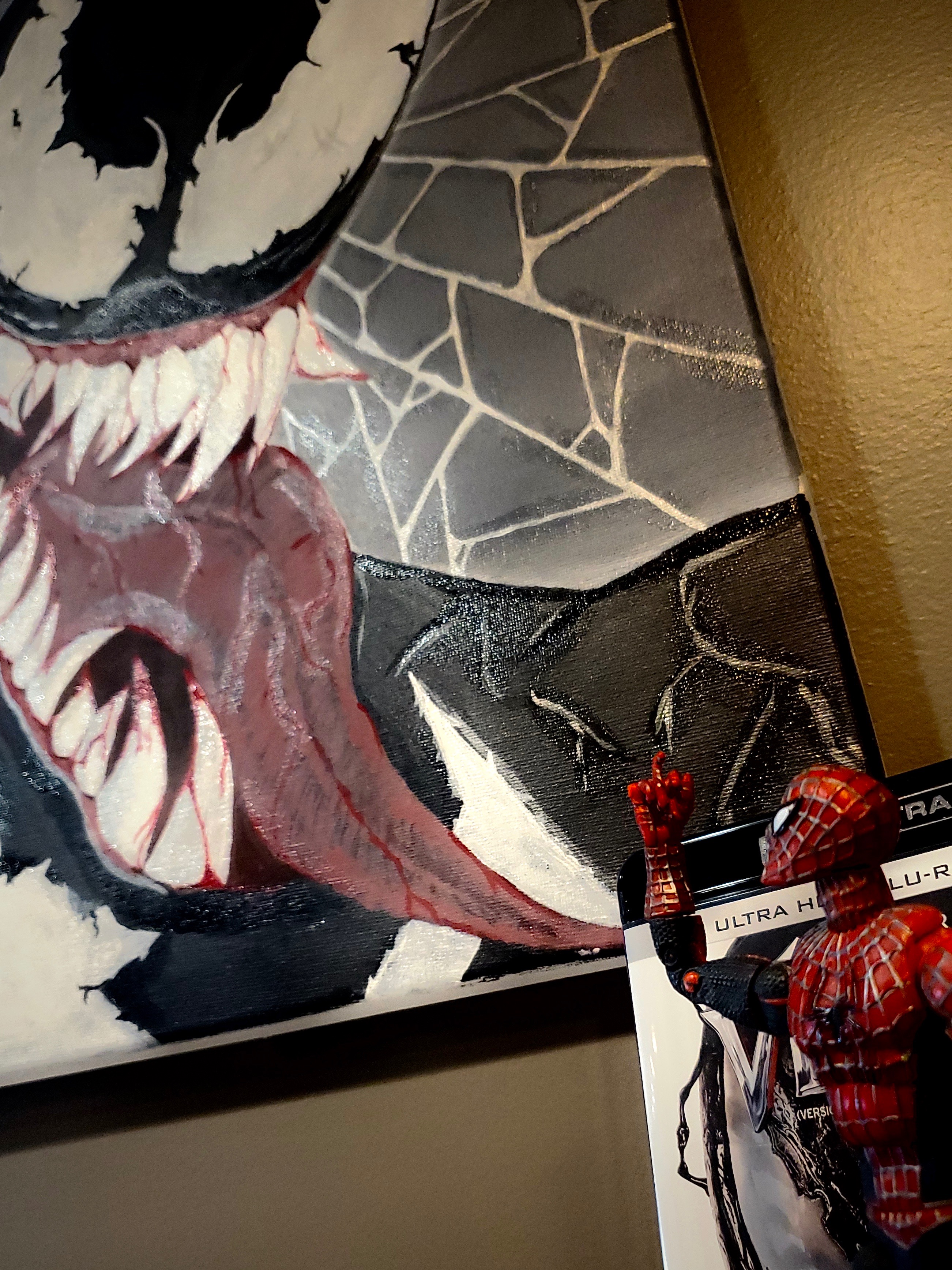 Spider-Man looks onto a painting of his arch-nemisis, Venom.