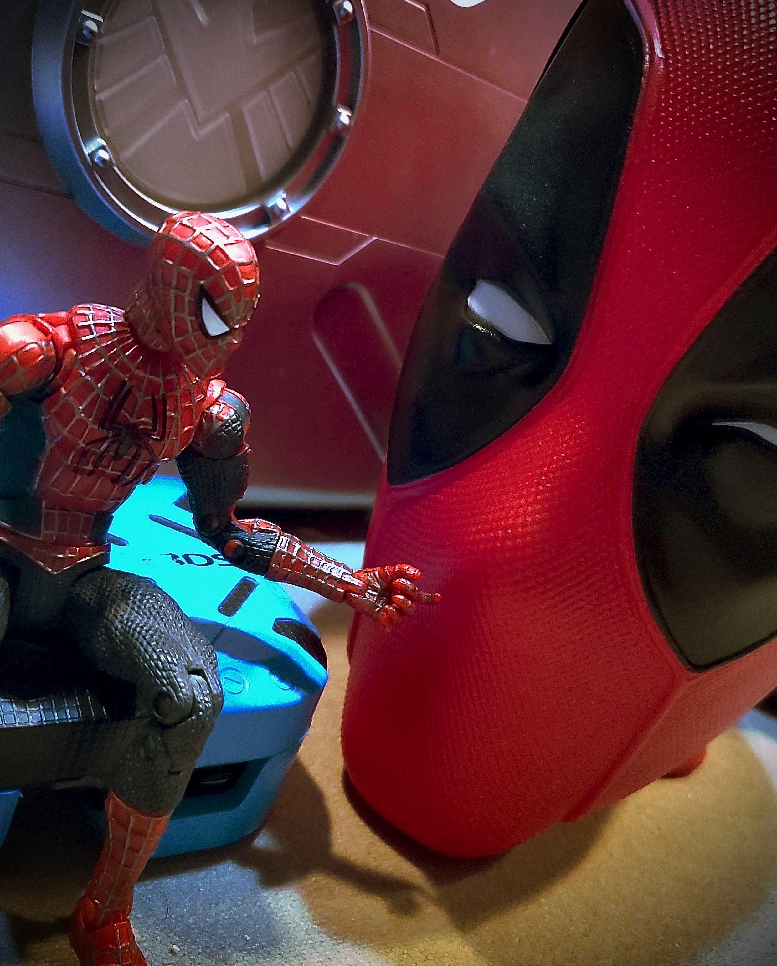 Spider-man toy having a discussion with Deadpool head